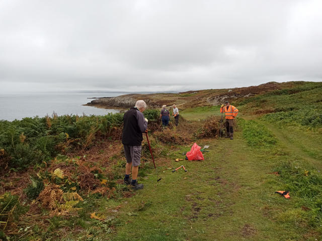 Volunteers removing overgrowth from the footpath